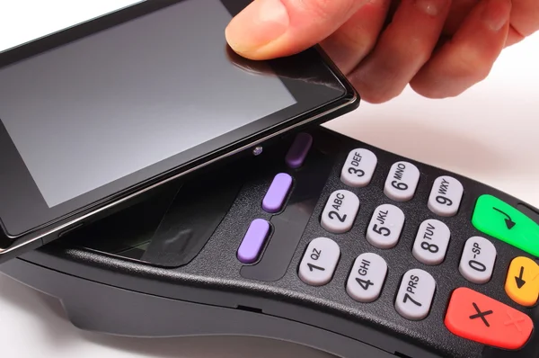 Рука женщины, платящей с помощью технологии NFC на мобильном телефоне — стоковое фото