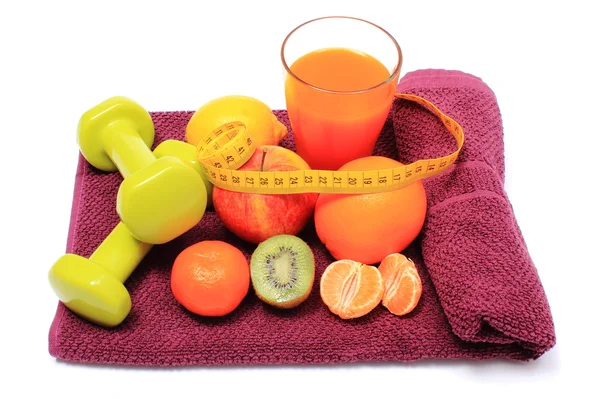 Frutas frescas com fita métrica, copo de suco e halteres — Fotografia de Stock