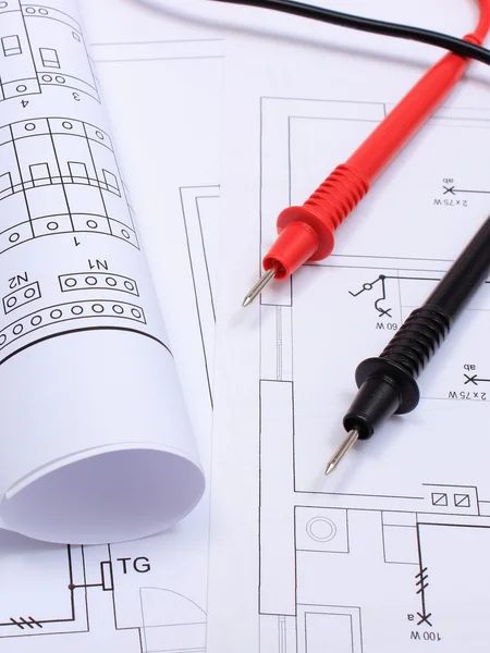 Rolled electrical diagrams and cables of multimeter on drawing of house — Stock Photo, Image
