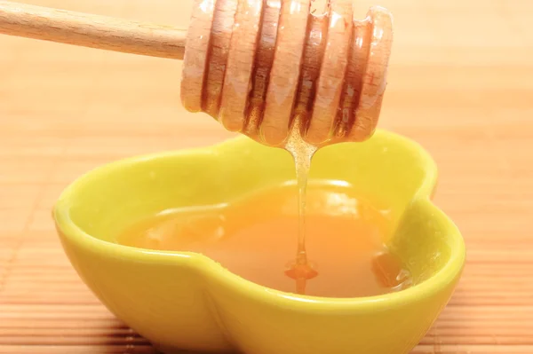 Honey with honey dipper in glass bowl — Stock Photo, Image