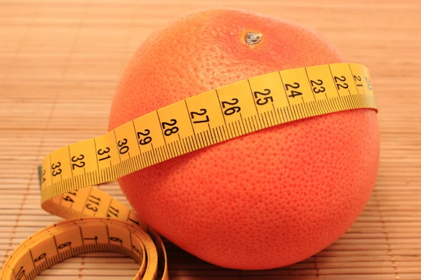 Fresh grapefruit and tape measure on wooden background — Stock Photo, Image