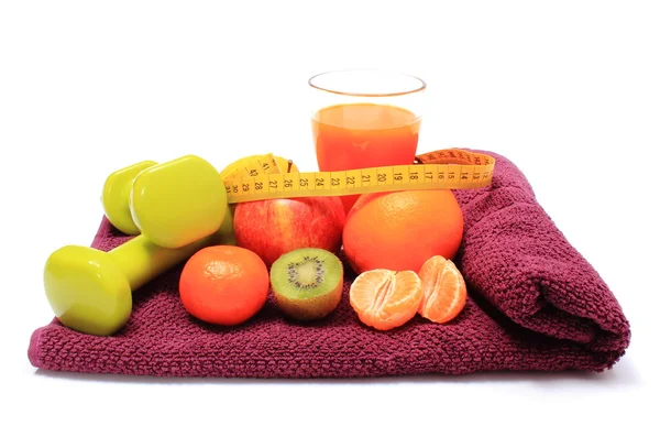 Fresh fruits with tape measure, glass of juice and dumbbells — Stock Photo, Image