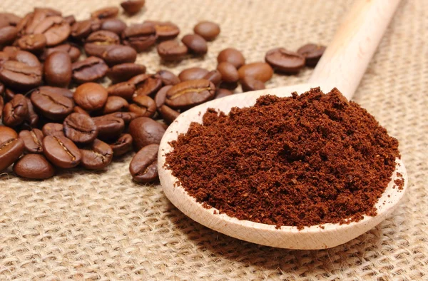 Kaffe på trä scoop och korn i bakgrunden — Stockfoto
