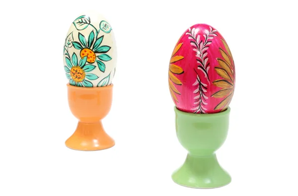 Coloridos huevos de Pascua en tazas verdes y naranjas. Fondo blanco — Foto de Stock