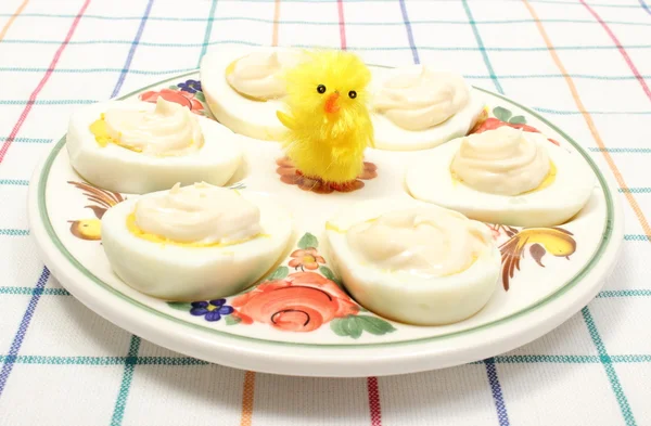 Metades de ovos com maionese e frango amarelo em prato colorido — Fotografia de Stock