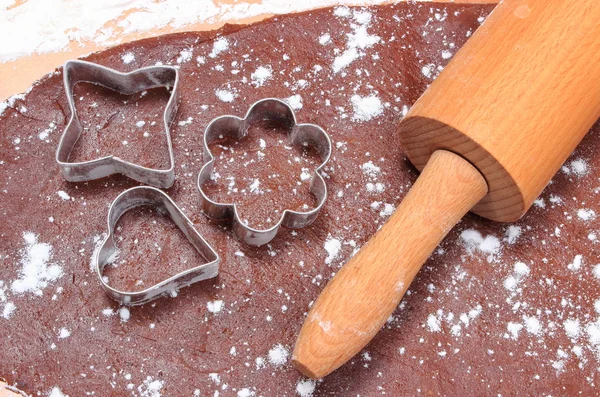 Cookie cutters and rolling pin on dough for cookies — Stock Photo, Image