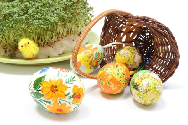 Uova di Pasqua in cesto di vimini rovesciato e cuculo verde — Foto Stock