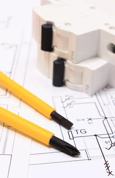 Screwdriver and electric fuse on construction drawing of house Stock Image