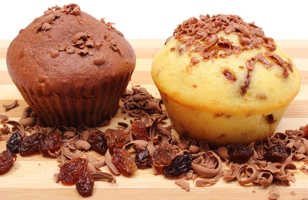 Fresh baked muffins and grated chocolate on wooden cutting board — Stock Photo, Image
