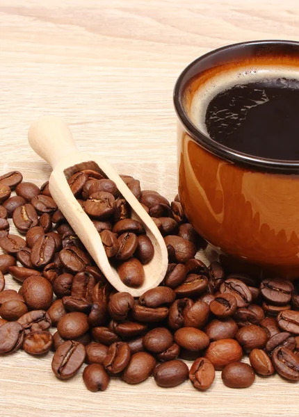 Hoop koffie korrels en kopje drank — Stockfoto