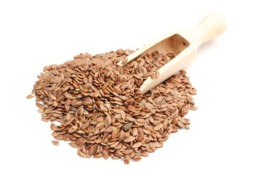 keten tohumu beyaz zemin üzerine tahta kaşıkla yığını