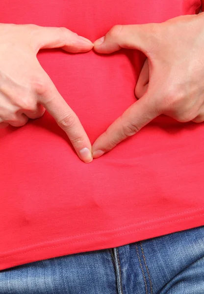 Händer i hjärtat formen på magen, symbol för kärlek — Stockfoto