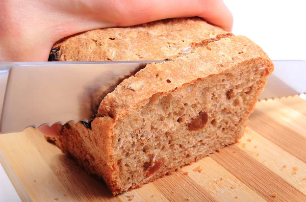 Mão de mulher cortando pão fresco assado — Fotografia de Stock