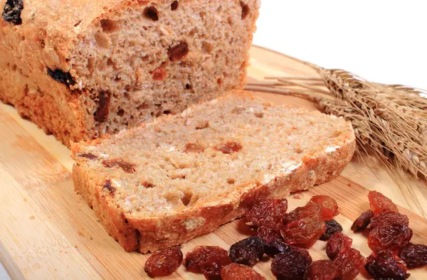 Fresh baked bread, ears of wheat and raisins — Stock Photo, Image