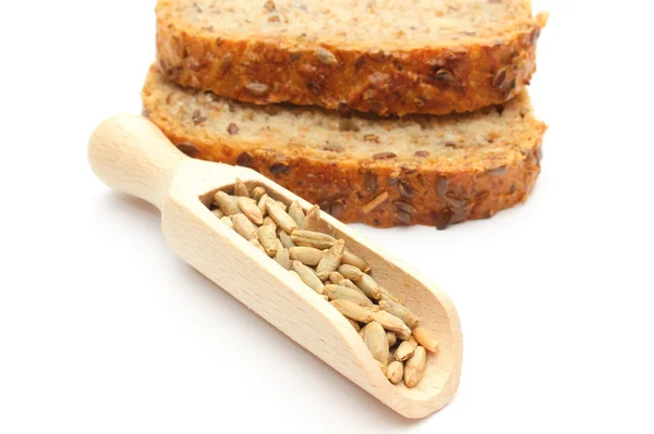 Natural rye grain on wooden spoon and pieces of bread — Stock Photo, Image