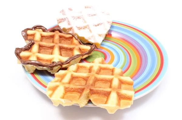 Waffles em forma de coração deitado em placa colorida. Fundo branco — Fotografia de Stock