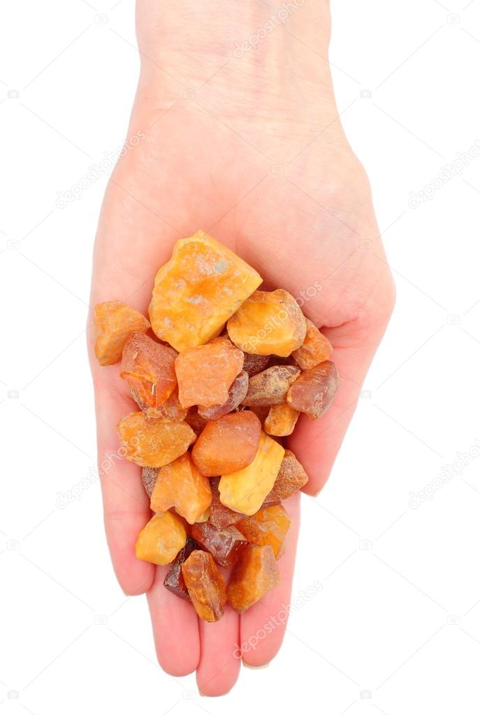 Hand of woman with raw ambers on white background