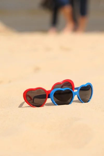 Colorati occhiali da sole a forma di cuore sulla sabbia — Foto Stock
