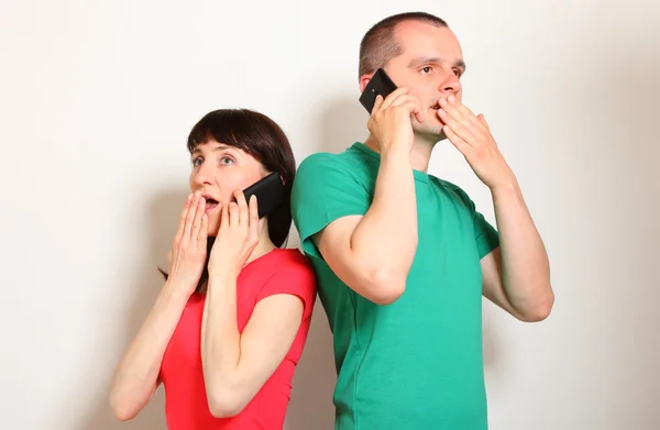 Chockad kvinna och man talar i mobiltelefon — Stockfoto