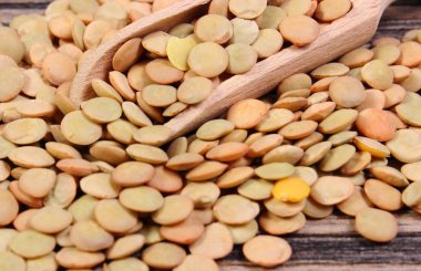 Ahşap zemin üzerine kaşıkla yeşil mercimek yığını