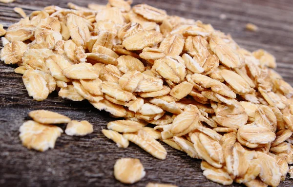 Heap of oat flakes on wooden background — Stock Photo, Image