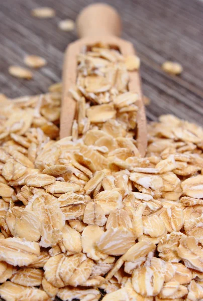 Copos de avena con cuchara sobre fondo de madera — Foto de Stock