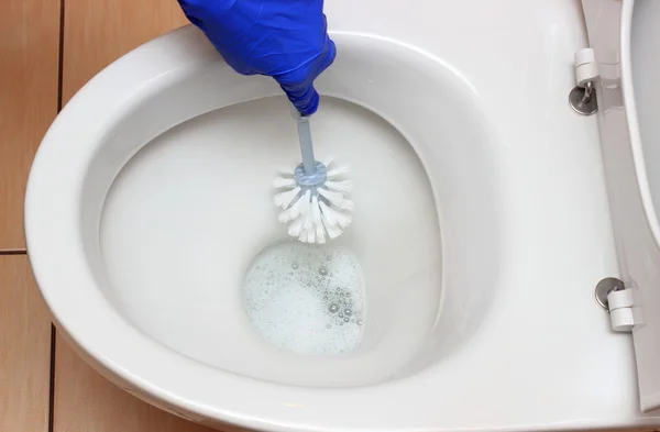 Χέρι της γυναίκας σε μπλε γάντι καθαρισμού της τουαλέτας — Φωτογραφία Αρχείου
