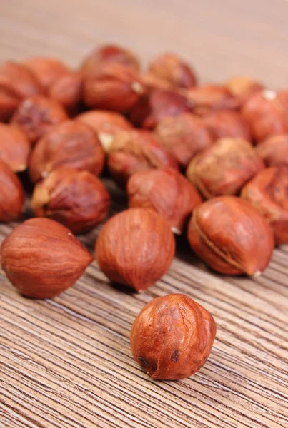 Heap of brown hazelnut on wooden table — Stock Photo, Image