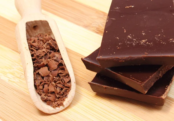 Pila de chocolate negro y rallado en cuchara de madera — Foto de Stock