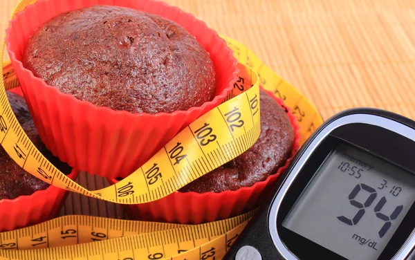 Glukometer, Muffins in roten Tassen und Maßband — Stockfoto