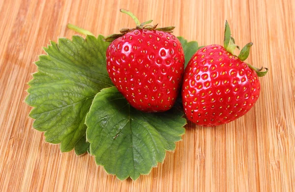 Fraise avec feuilles sur la surface en bois — Photo