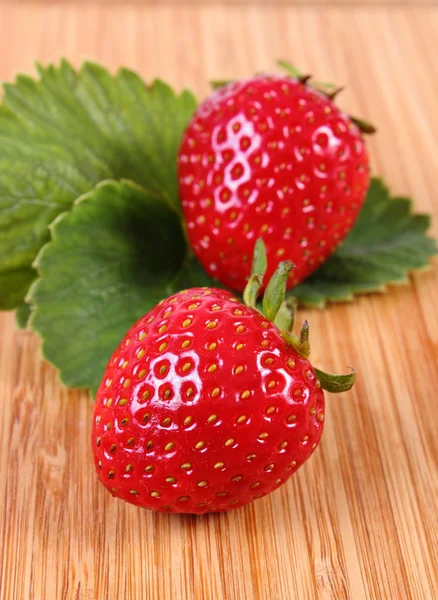 Fraise avec feuilles sur la surface en bois — Photo