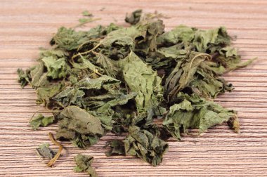 Ahşap yüzey üzerinde kurutulmuş ısırgan otu yığını