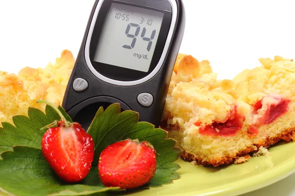 Glucose meter and pieces of yeast cake with strawberries — 스톡 사진