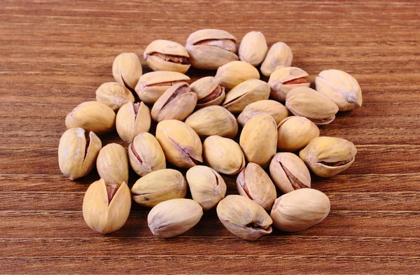 Nueces de pistacho sobre mesa de madera, alimentación saludable —  Fotos de Stock