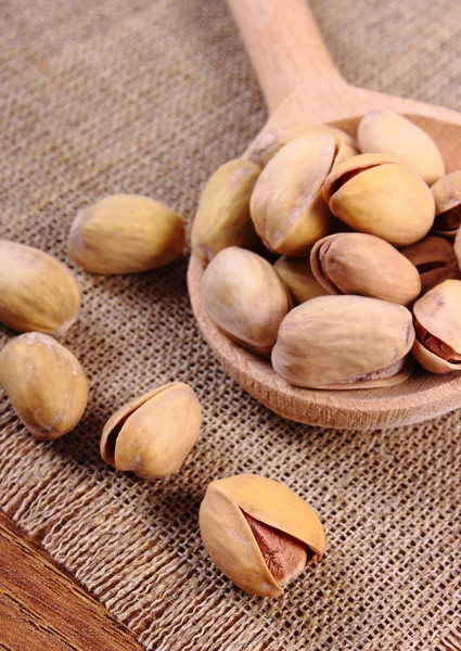 Pistacchi con cucchiaio sul tavolo di legno, alimentazione sana — Foto Stock