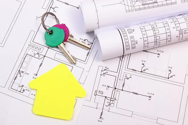 Casa de papel amarillo, llaves de casa, rollos de diagramas sobre dibujo de construcción — Foto de Stock