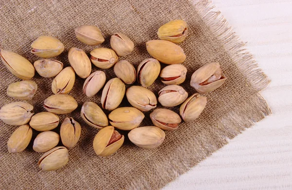 Nueces de pistacho sobre mesa de madera blanca, alimentación saludable —  Fotos de Stock