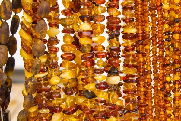 Блестящие женские янтарные ожерелья на ларьке на базаре — стоковое фото
