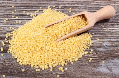 Ahşap zemin üzerine kaşıkla darı kabuğu çıkarılmış tane yığını