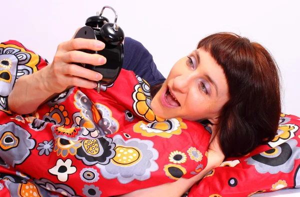 Shocked and amazed woman looking at ringing alarm clock — Zdjęcie stockowe