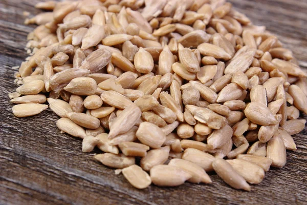 Heap of sunflower seeds on wooden background — Stock Photo, Image