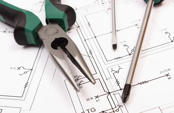 Metal pliers and screwdriver on electrical construction drawing of house — Stock Photo, Image