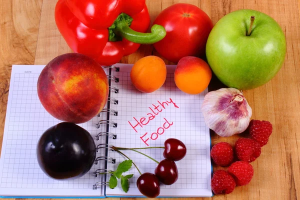 Frutas y verduras con cuaderno, adelgazamiento y alimentos saludables — Foto de Stock