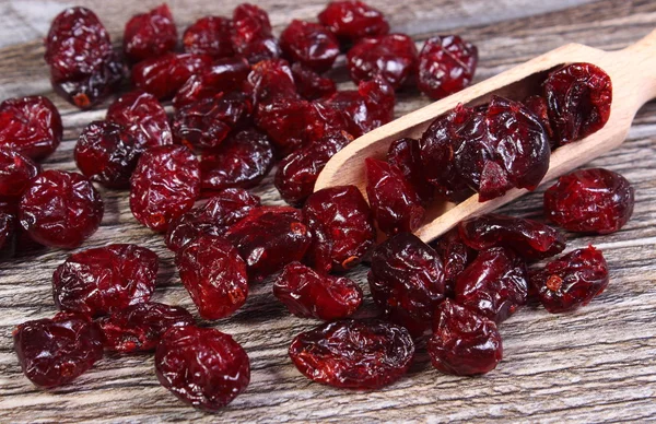 Heap of red cranberries with spoon on wooden table — Stock Photo, Image