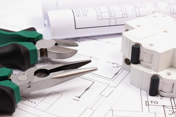 Work tools, electric fuse and rolls of diagrams on construction drawing of house — Stock Photo, Image