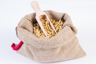Organic oat grains in jute bag, healthy nutrition, white background