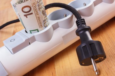 Rolls of polish currency money in electrical power strip and disconnected plug, energy costs clipart
