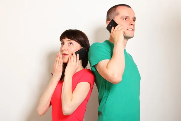 Schockierte Frau und Mann telefonieren miteinander — Stockfoto