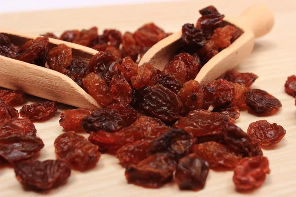 Raisins marron avec cuillère sur table en bois, saine alimentation — Photo